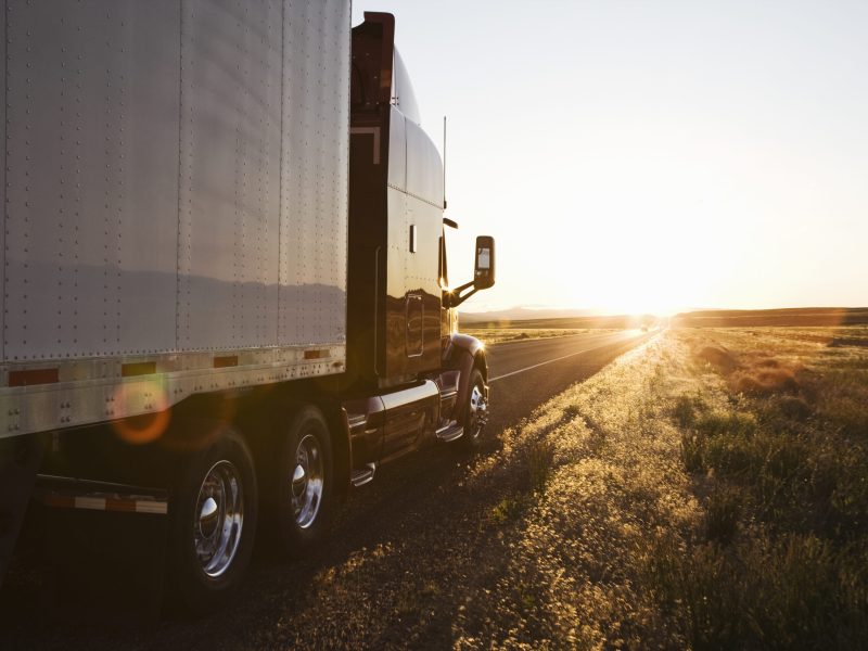 Side view of a trailer and truck on the road at sunset in eastern Washington, USA