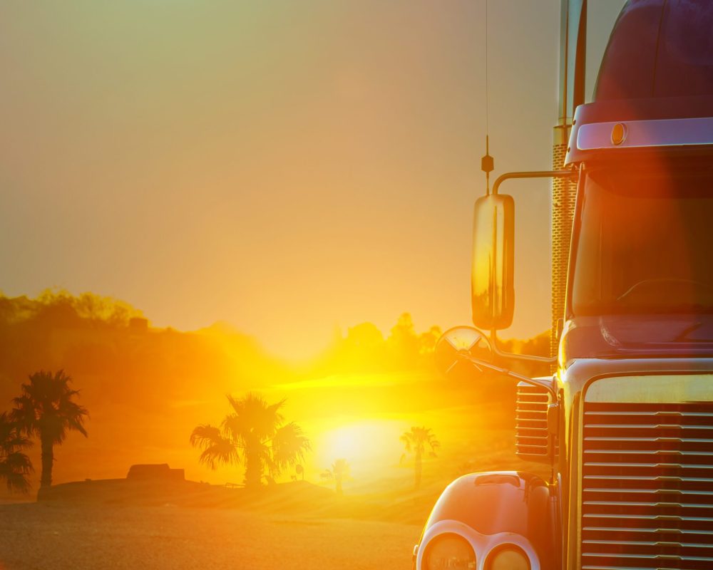 Truck dashboard with on the countryside road in motion against with sunset Truck dashboard on the countryside road in motion against with sunset